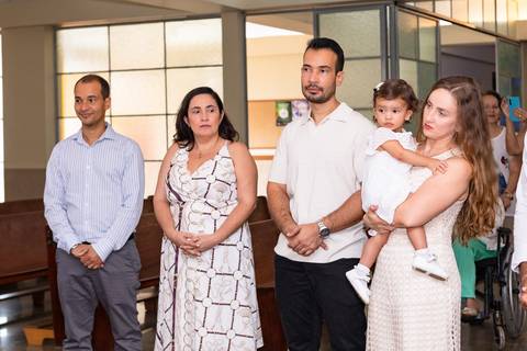 Momentos de fé e espiritualidade na infância. Registro do rito de batismo da Aurora com a presença dos padrinhos e familiares na igreja.'