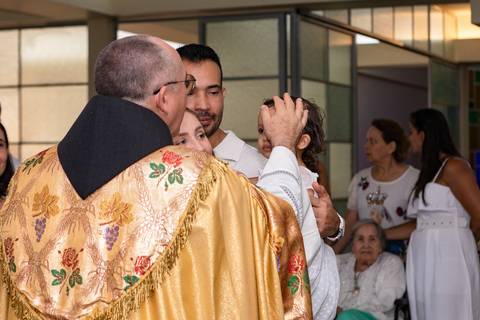 Momentos de fé e espiritualidade na infância. Registro do rito de batismo da Aurora com a presença dos padrinhos e familiares na igreja.'