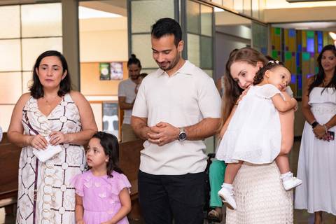 Momentos de fé e espiritualidade na infância. Registro do rito de batismo da Aurora com a presença dos padrinhos e familiares na igreja.'