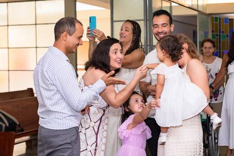 Momentos de fé e espiritualidade na infância. Registro do rito de batismo da Aurora com a presença dos padrinhos e familiares na igreja.'