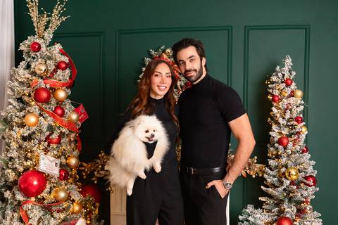 Fotografia de família com cachorro em Brasília. Casal com look preto coordenado em momento espontâneo no estúdio.'