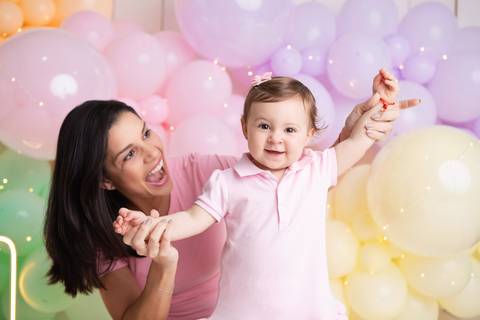 Conexão materna e comemoração de aniversário infantil. Registro espontâneo de mãe e filha em estúdio no Distrito Federal.'
