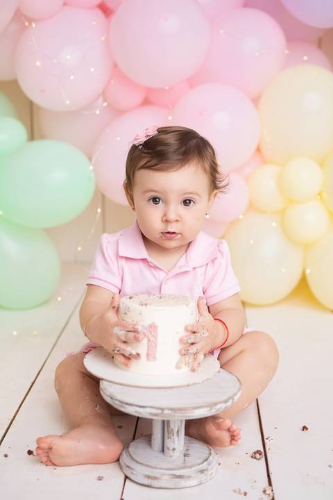 Pura felicidade e comemoração infantil. Cecília celebrando seu primeiro ano de vida com muita alegria no estúdio.'
