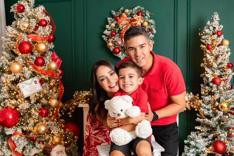 Laços de amor e carinho familiar. O casal Paula e Ernane compartilhando sorrisos com o filho mais velho João no Distrito Federal.'