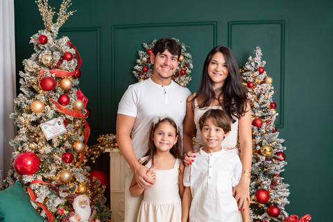 Retrato de família em Brasília - DF. Bianca e Lalbert com os filhos vestindo roupas claras coordenadas em momento de união.'