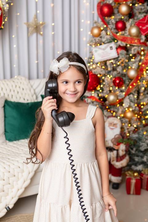 Momentos lúdicos e imaginação no crescimento infantil. A pequena Liz interagindo com telefone antigo de forma divertida em Brasília.'