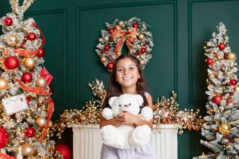 A doçura e a vivacidade da infância. A menina Maria Teresa posando sorridente com brinquedo de pelúcia no DF.'