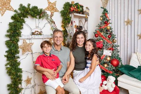 Momentos descontraídos em família no fim de ano. Pais e filhos compartilhando abraços e cumplicidade no estúdio.'