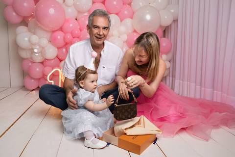 Momento de afeto e memória familiar no estúdio. Andrea e Marcelo ajudando a filha a abrir presente especial de aniversário. bolsa Louis Vuitton'