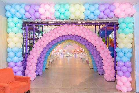 Decoração de festa infantil de um ano em Brasília. Entrada com arco de balões coloridos em tons pastel.'