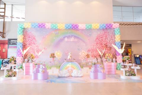 Mesa de bolo decorada com tema arco-íris e borboletas. Decoração de aniversário de um ano no Distrito Federal.'
