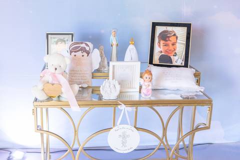 Mesa de recordações com fotos de criança em Brasília. Altar infantil.'