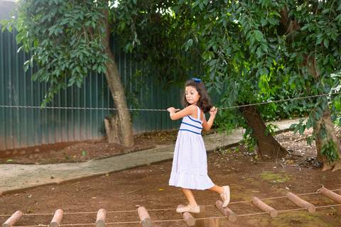 Atividades recreativas e bem-estar infantil. Maria Teresa correndo livremente pela área externa do local do evento.'