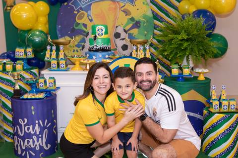 Conexão familiar e carinho no aniversário. O pequeno Lucas abraçado com os pais em momento de afeto.'