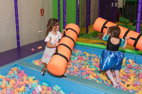 Brincadeiras infantis e atividades recreativas em Brasília. Crianças se divertindo no circuito de bolinhas.'