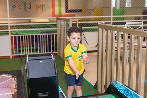 Expressão espontânea do aniversariante no parquinho infantil em Brasília.'