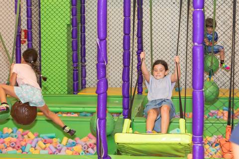 Momentos de diversão e liberdade no parquinho infantil durante o aniversário.'