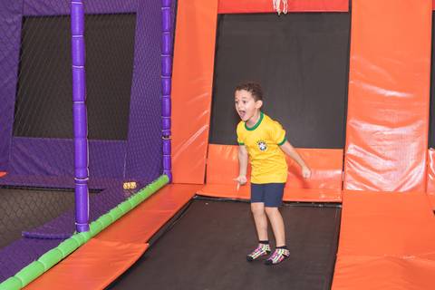 Entusiasmo e comemoração vibrante do aniversariante em brinquedo de recreação.'