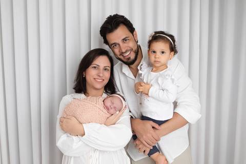 Fotografia de família com recém-nascido em Brasília. O casal Lívia e Daniel com as filhas Amanda e Laura em ensaio newborn tranquilo no Lago Sul, DF. Letícia Franco Fotos.'