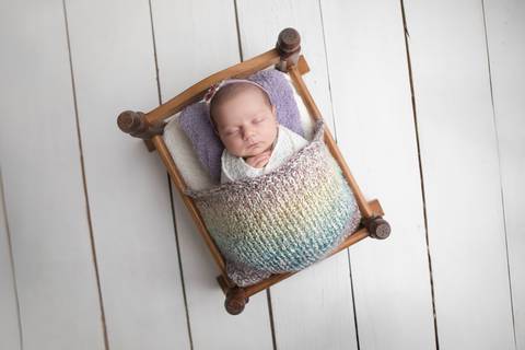 Ensaio newborn seguro da bebê Laura em Brasília. Fotografia de recém-nascido em tons de rosa e lilás na região do Jardim Botânico e Lago Sul, DF. Fotógrafa Letícia Franco.'