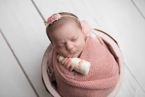 Ensaio newborn seguro da bebê Laura em Brasília. Fotografia de recém-nascido em tons de rosa e lilás na região do Jardim Botânico e Lago Sul, DF. Fotógrafa Letícia Franco.'