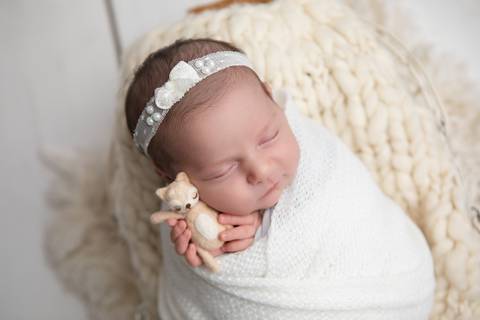 Ensaio newborn seguro da bebê Laura em Brasília. Fotografia de recém-nascido em tons de rosa e lilás na região do Jardim Botânico e Lago Sul, DF. Fotógrafa Letícia Franco.'
