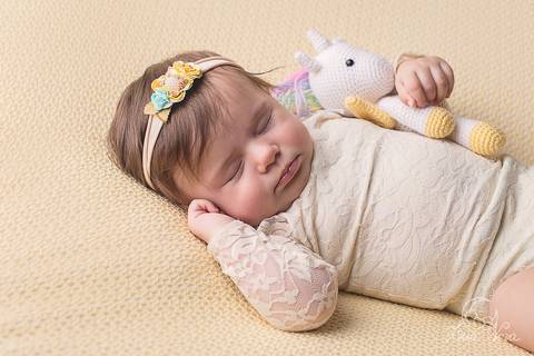 fases do bebe acompanhamento gabriela 03 3 meses dormindo amarelo unicórnio colorido body renda creme ensaio no pufe manta fundo amarelo mão pra cima'