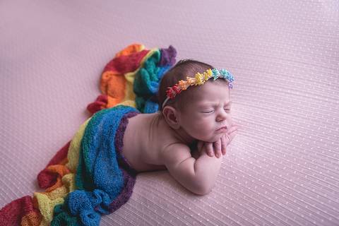 bebe recem nascido newborn book preço valor brasilia df pose mão no queixo mãozinha queixinho barriga pra baixo fundo rosa com branco e headband faixa cabelo arco-iris rainbow baby bebe tempestade felicidade paninho wrap branco por cima arco iris colorido'
