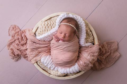 bebe recem nascido newborn book preço valor brasilia df pose barriguinha barriga pra cima fundo madeira headband faixa cabelo flor pérolas lã touca cobertinha segurando prop enrolada enrolado paninho cesto redondo tina paninho wrap rosa seco'