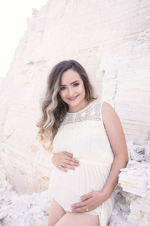 ensaio gestante mamãe tasciane lugar dos sonhos mineradora toda de branco mão na barriga de frente sorrindo'