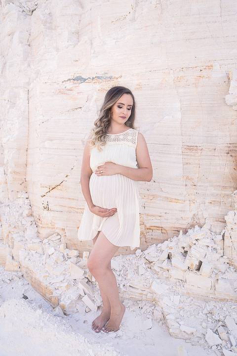 ensaio gestante mamãe tasciane lugar dos sonhos mineradora toda de branco mão na barriga olhando pra baixo'