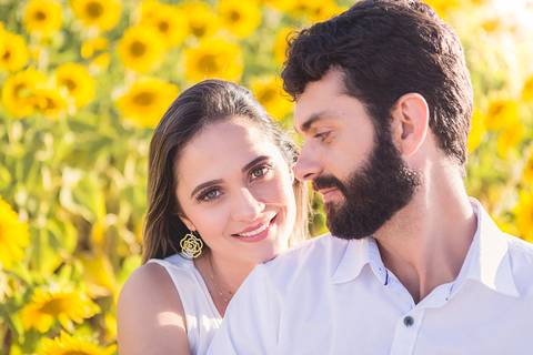 casal book rodolfo priscilla girassol abraçando sorrindo ele olhando pra ela'