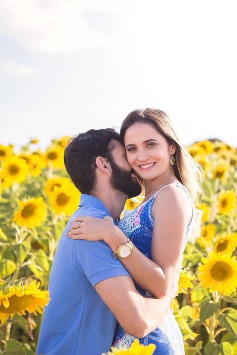 casal book rodolfo priscilla girassol abraçando sorrindo ele dando cheirinho nela'