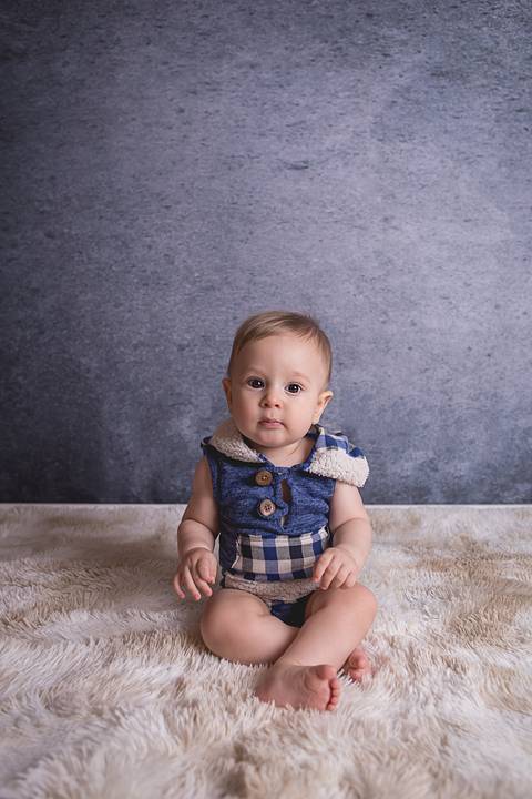 bebe book ensaio acompanhamento 06 07 meses fundo azul chão madeira caixinha de coração roupa azul de capuz sorrindo bebe sério tapete'