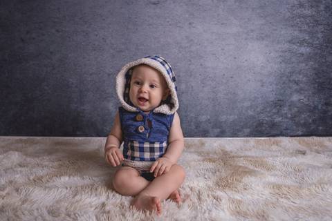 bebe book ensaio acompanhamento 06 07 meses fundo azul chão madeira caixinha de coração roupa azul de capuz sorrindo bebe sério tapete'