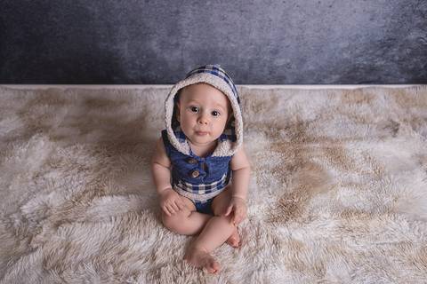 bebe book ensaio acompanhamento 06 07 meses fundo azul chão madeira caixinha de coração roupa azul de capuz sorrindo bebe sério tapete'