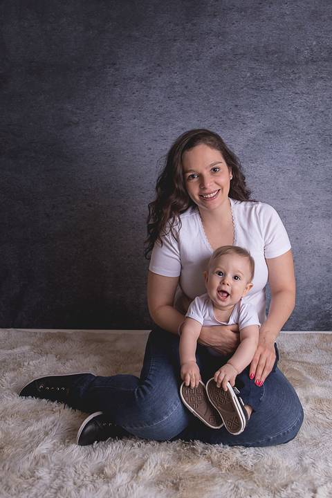 bebe book ensaio acompanhamento 06 07 meses fundo azul chão madeira caixinha de coração roupa azul de capuz sorrindo bebe sério tapete com a mamãe jeans e blusa branca'