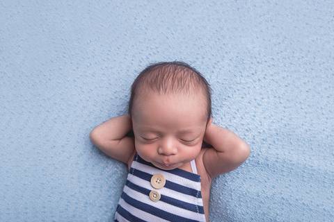 newborn new born recem nascido bebe fotografo fotografa brasilia df foografia menino manta branca com azul bumbum touca e calça mão atrás da cabeça'