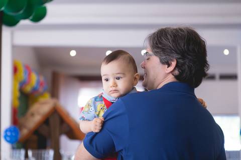 papai segurando bebê aniversariante galinha pintadinha registrado pela fotógrafa Letícia Leticia Franco em brasília brasilia df'
