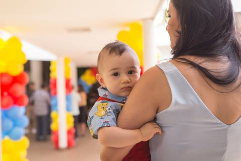 bebê no colo da mamãe sorrindo galinha pintadinha segurando no braço registrado pela fotógrafa Letícia Leticia Franco em brasília brasilia df'