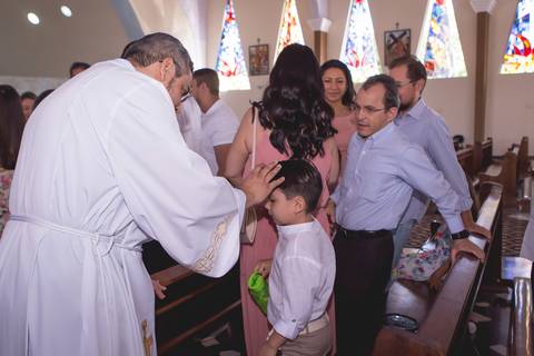 batizado brasilia df nossa senhora de fatima padre fazendo sinal da cruz na testa da criança registrado pela fotógrafa Letícia Leticia Franco em brasília brasilia df'