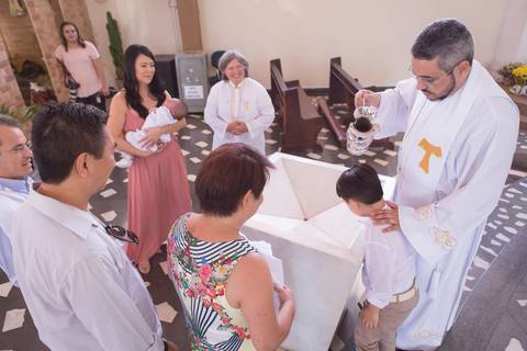 criança sendo batizado pelo padre na pia na igreja nossa senhora de fatima brasilia df registrado pela fotógrafa Letícia Leticia Franco em brasília brasilia df'