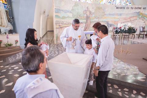 criança sendo batizado pelo padre na pia na igreja nossa senhora de fatima brasilia dfregistrado pela fotógrafa Letícia Leticia Franco em brasília brasilia df'