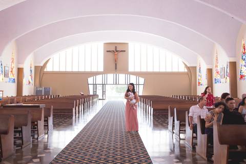 mãe segurando e acalmando bebe durante o batizado nossa senhora de fatima brasilia registrado pela fotógrafa Letícia Leticia Franco em brasília brasilia df'
