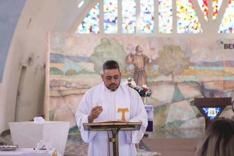 padre celebrando batizado na igreja nossa senhora de fatima brasilia df registrado pela fotógrafa Letícia Leticia Franco em brasília brasilia df'
