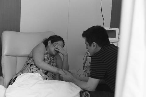 mãe tendo contração pai segurando a mão maternidade brasília parto fotografa fotografo fotógrafa brasília DF brasília/df gestante sala de pré parto mãe sentindo contração  fotografia grávida gestação gestacional registrado pela fotografa Letícia Franco'