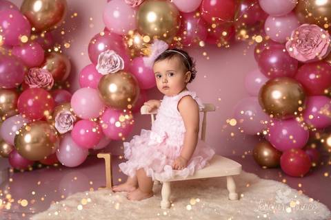 bebê sentada na cadeira balões rosa e dourado smash the cake fotografia primeiro ano com bolo registrado pela fotógrafa Letícia Leticia Franco em brasília brasilia df jardim botânico botanico'