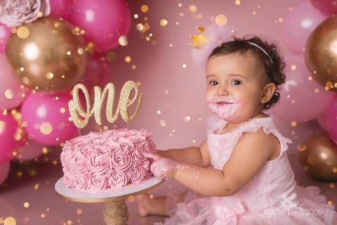 cenário completo com balões smash the cake arco desconstruído rosa e rourado com a mão no bolo rindo fotografia primeiro ano com bolo registrado pela fotógrafa Letícia Leticia Franco em brasília brasilia df jardim botânico botanico'