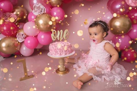 bebe com cara de susto balões rosa e dourado smash the cake fotografia primeiro ano com bolo registrado pela fotógrafa Letícia Leticia Franco em brasília brasilia df jardim botânico botanico'