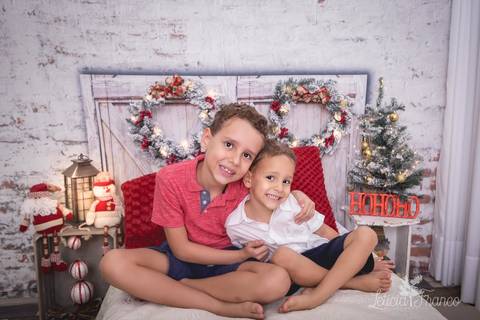ensaio de natal infantil criança touca de papai noel 2019 brasilia df registrado pela fotógrafa letícia franco quarto do papai noel cama arvore guirlanda lucas matheus'